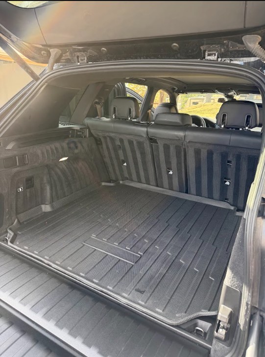 Freshly detailed SUV trunk with straight cleaning lines in the black cargo carpet